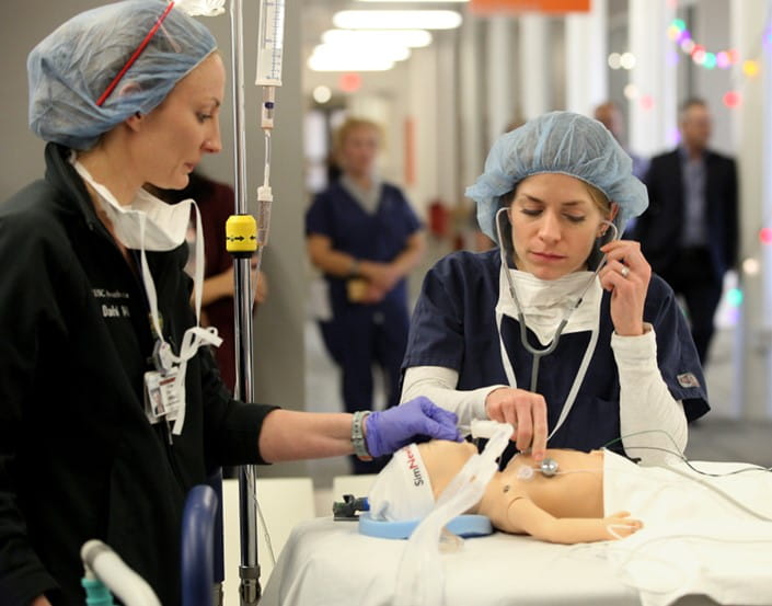 Doctors practice on a simulation manikin of a pediatric patient.
