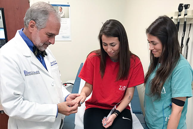 Richard Silver, M.D., with patients Haylee and Kaylee Thomas.