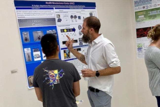 Dr. Brett Froeliger explains research to a student