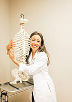 Photo of Dr Renee hugging a plastic skeleton 