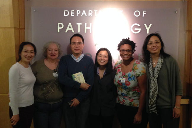 Lab members posing with Department of Pathology sign