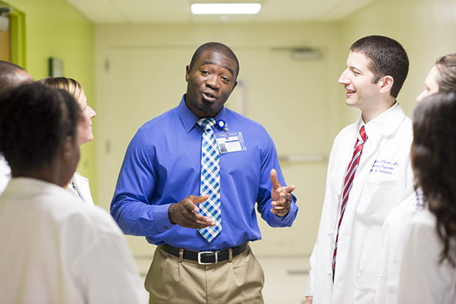 Dr. Odulana speaking with a group of physicians