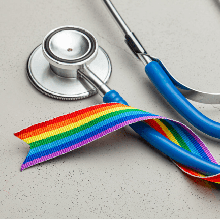 Photo of stethoscope with a rainbow pride ribbon wrapped around it