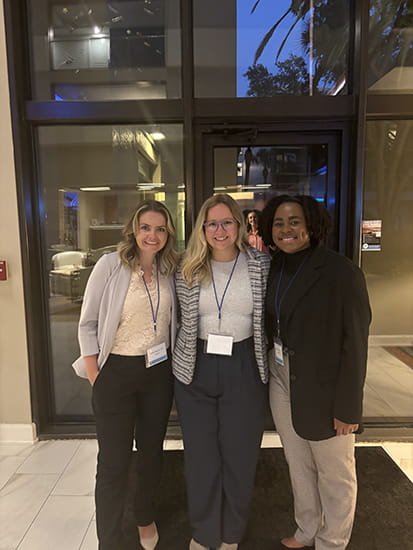Three smiling women at a conference