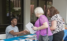 MPH student shakes hands with woman visiting 2017 Public Health Week Information Booth