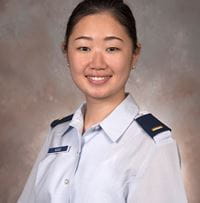Sonya Kang smiles in uniform against a grey background.