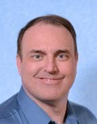 white man with blue collared shirt and blue background