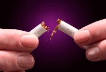 Close up image of a person snapping a cigarette in half
