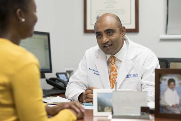 Dr. Ravi Veeraswamy meeting with a member of his staff in his office.
