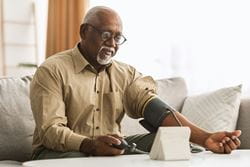 older male taking blood pressure