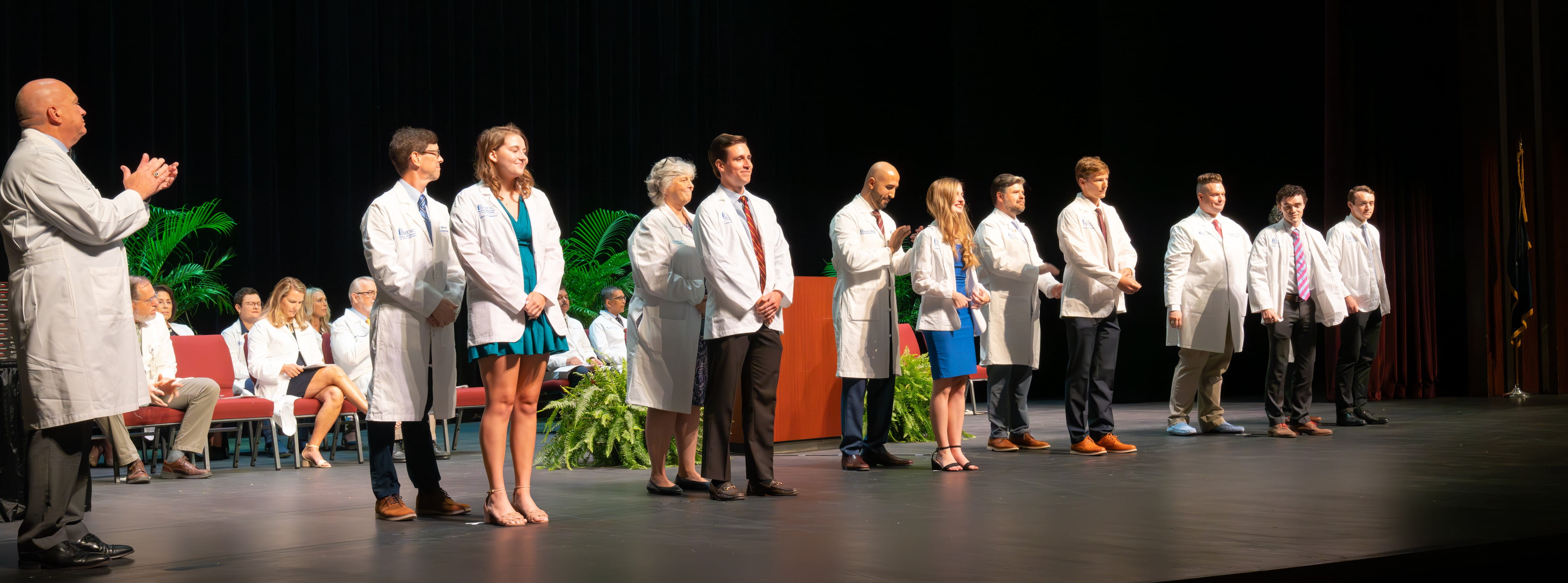 Students put on their new white coats during the College of Medicine White Coat ceremony